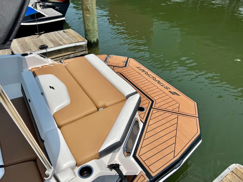 Slide: The Image of 2023 Starcraft SVX 210 IO boat docked, featuring tan seating and swim platform. - 4