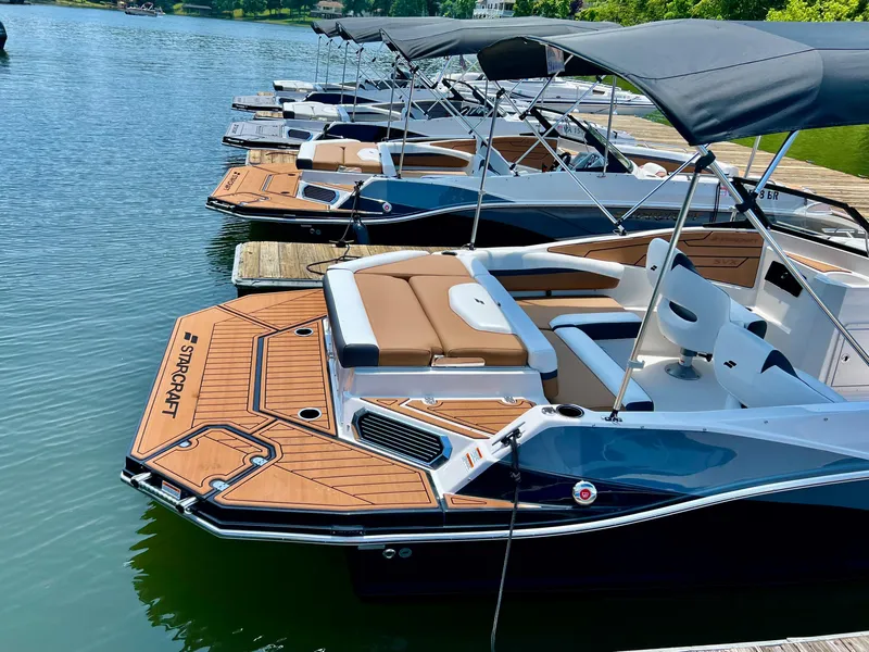 Slide: The Image of 2023 Starcraft SVX 210 IO boats docked in a serene lake setting. - 9