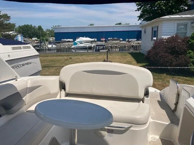 Slide: The Image of 2006 Chaparral 276 SSi boat interior with seating and table, docked near marina. - 4