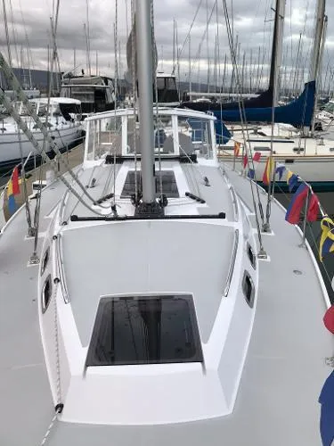 Slide: The Image of 2018 Catalina 425 sailboat docked, adorned with colorful flags, overcast sky. - 15