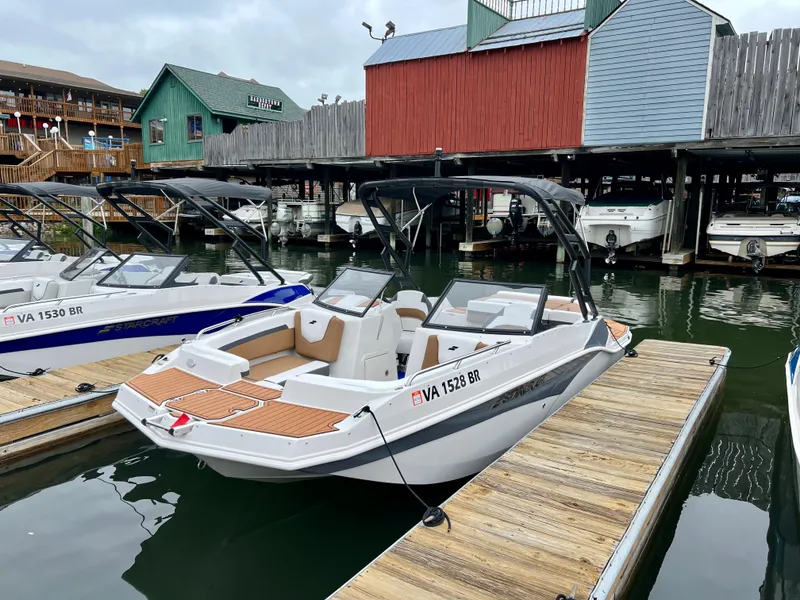 The Image of 2023 Starcraft SVX 210 IO Wake Tower boat docked at a marina. - 0