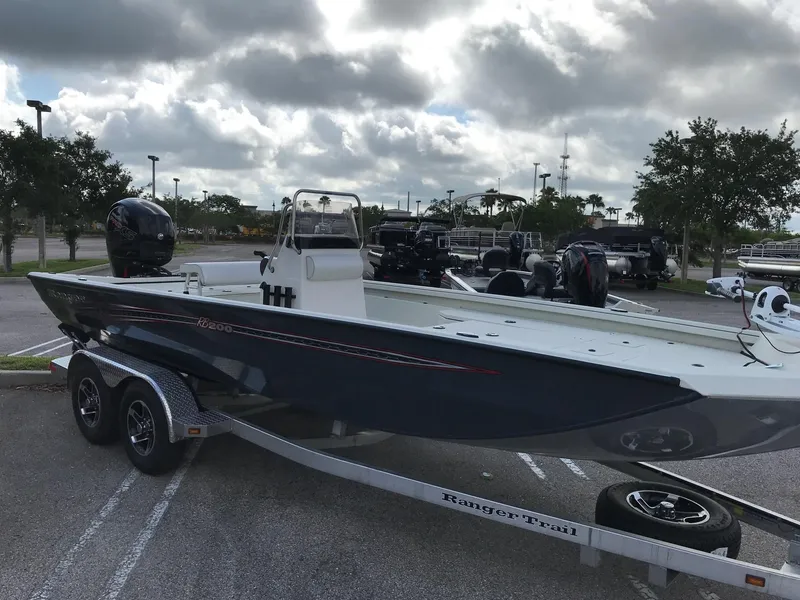Slide: The Image of 2023 Ranger RB200 boat on trailer in parking lot under cloudy sky. - 2