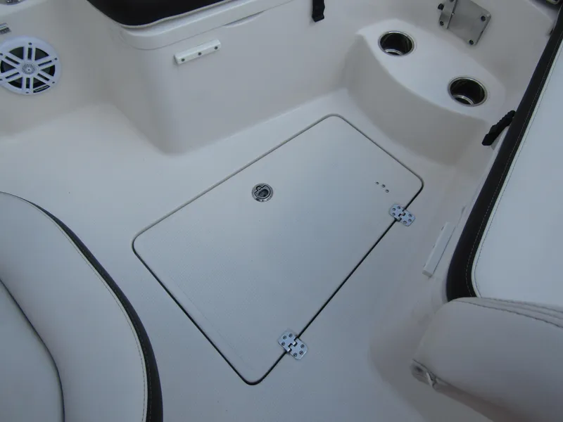 Slide: The Image of 2024 Sailfish 242 CC boat interior with storage compartment and cup holders. - 12
