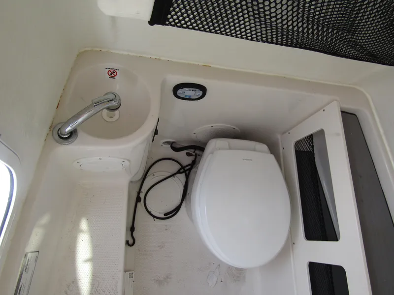 Slide: The Image of 2024 Sailfish 242 CC boat interior with toilet and sink. - 16