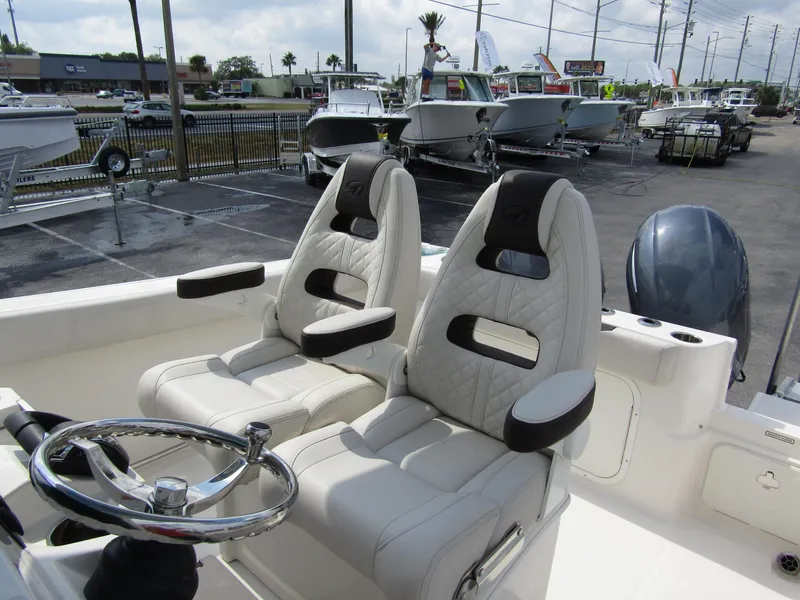 Slide: The Image of 2024 Sailfish 242 CC boat interior with dual captain's chairs and steering wheel. - 18