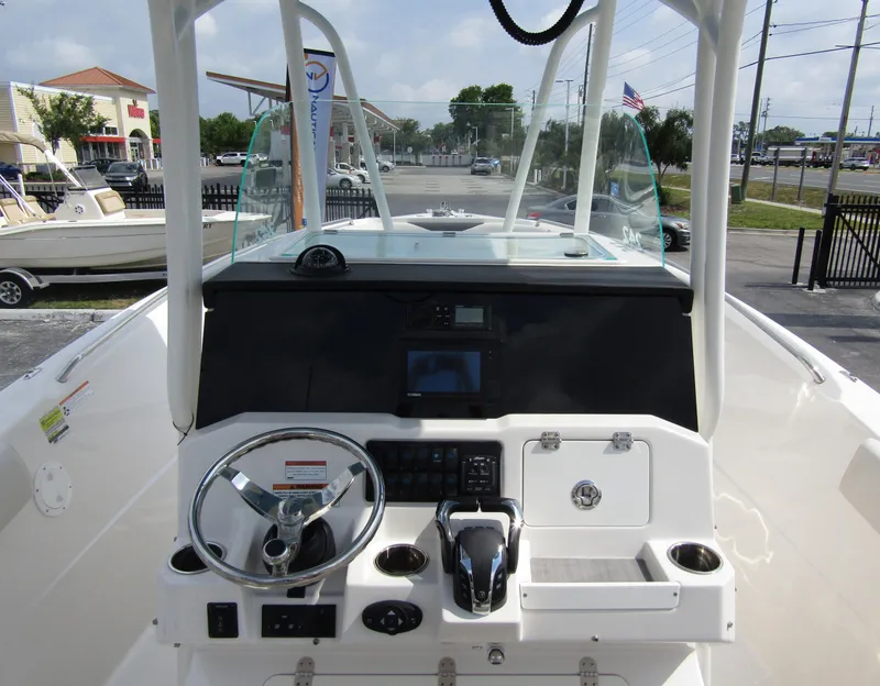 Slide: The Image of 2024 Sailfish 242 CC boat helm with steering wheel and control panel. - 19