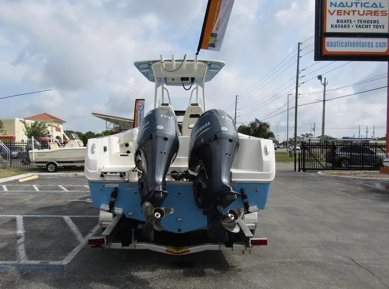 Slide: The Image of 2024 Sailfish 242 CC boat with twin outboard engines at a dealership. - 2