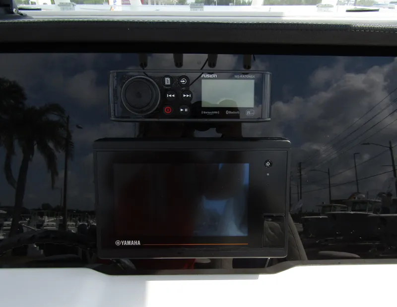 Slide: The Image of 2024 Sailfish 242 CC dashboard with Yamaha display and Fusion audio system. - 24