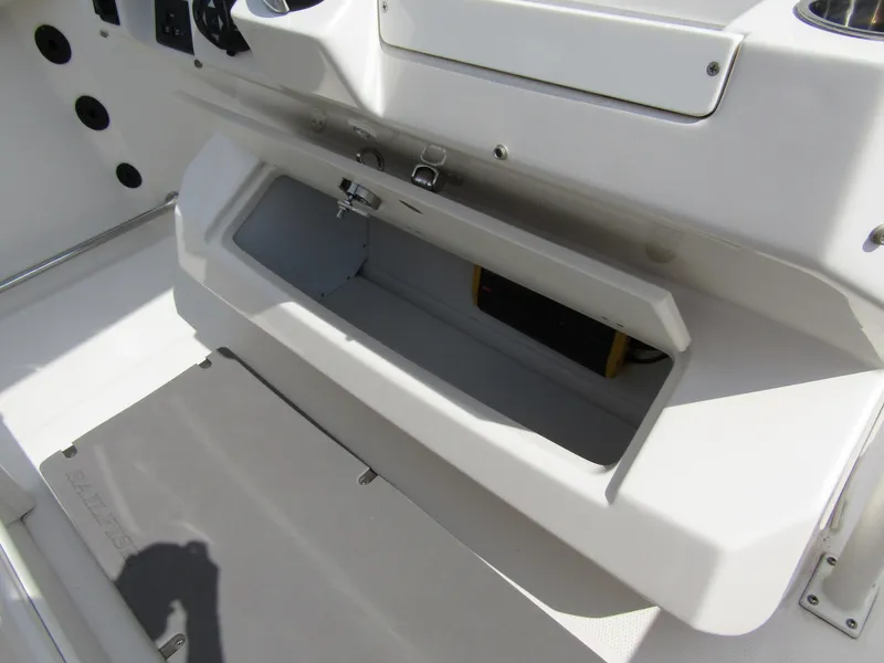 Slide: The Image of 2024 Sailfish 242 CC boat storage compartment and control panel. - 30
