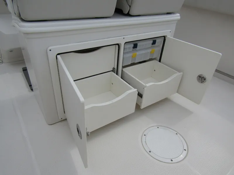 Slide: The Image of 2024 Sailfish 242 CC boat storage compartments with open drawers and tackle boxes. - 37