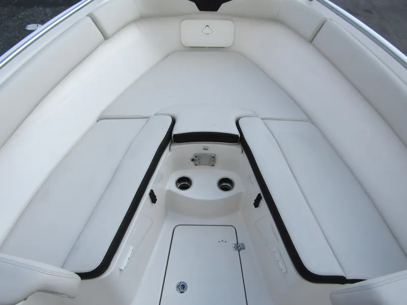 Slide: The Image of 2024 Sailfish 242 CC boat interior with white cushioned seating and storage compartments. - 8