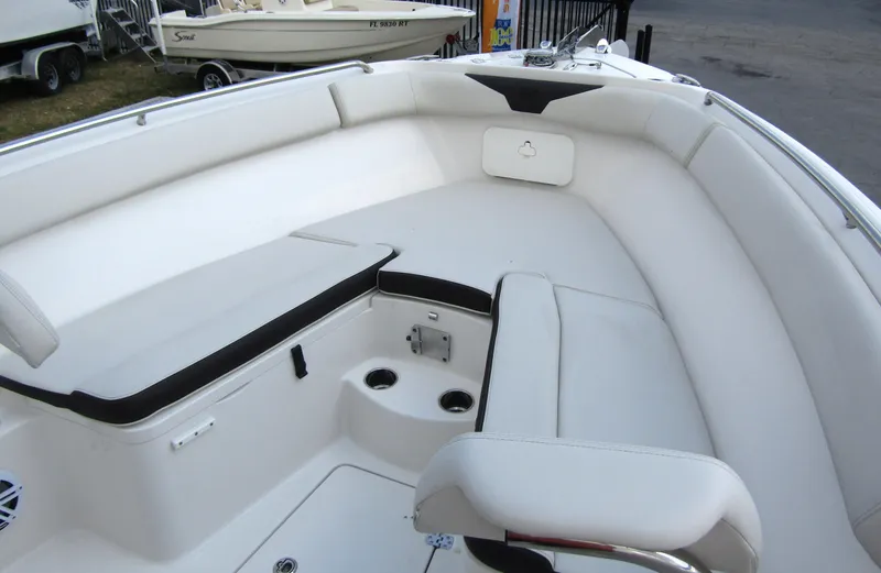 Slide: The Image of 2024 Sailfish 242 CC boat interior with white cushioned seating and storage compartments. - 9