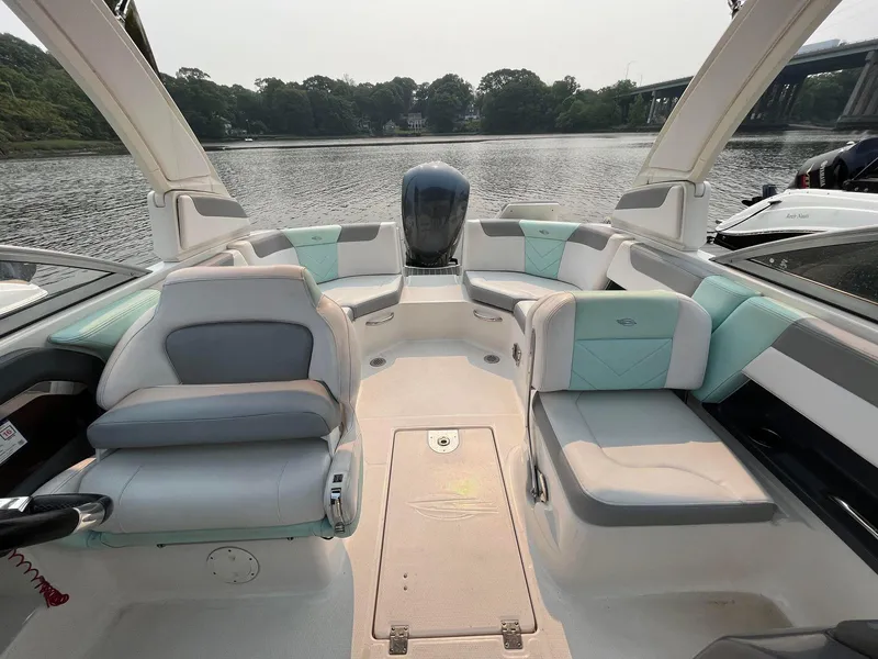 Slide: The Image of 2020 Chaparral Suncoast 250 boat interior with seating, on a calm lake. - 3