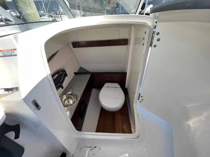 Slide: The Image of 2020 Chaparral Suncoast 250 boat interior with compact bathroom and sink. - 9