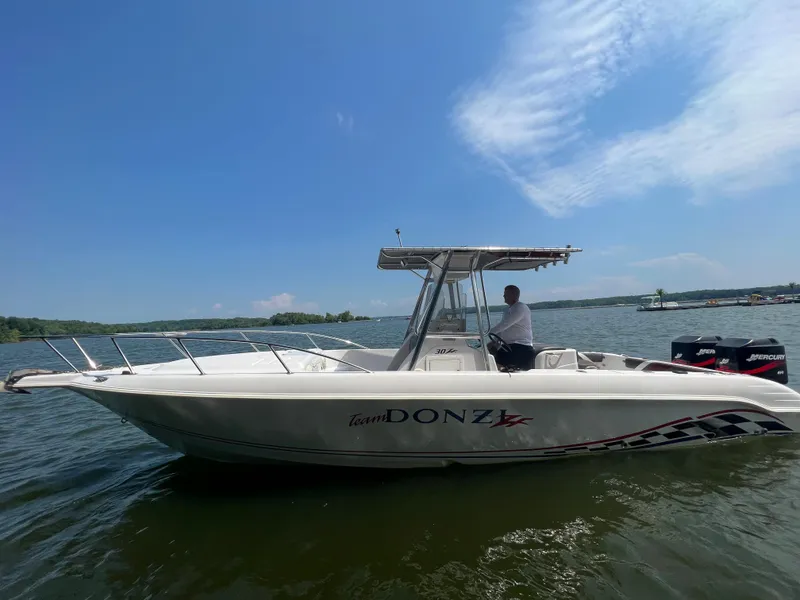 Slide: The Image of 1999 Donzi 30 ZF boat on a lake with a person at the helm. - 21
