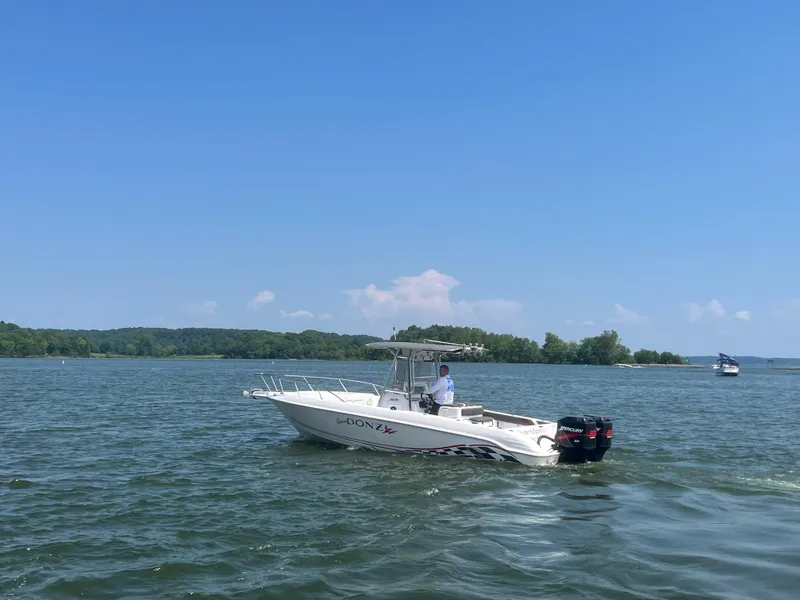 Slide: The Image of 1999 Donzi 30 ZF boat cruising on a lake under a clear blue sky. - 28