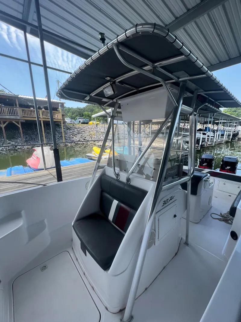 Slide: The Image of 1999 Donzi 30 ZF boat with T-top and seating at dock. - 34