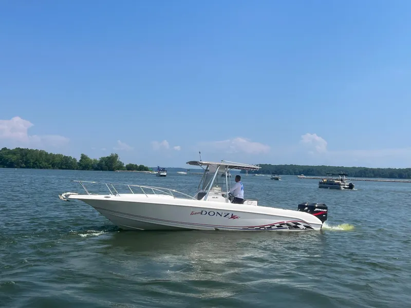 Slide: The Image of 1999 Donzi 30 ZF boat cruising on a lake under a clear blue sky. - 4