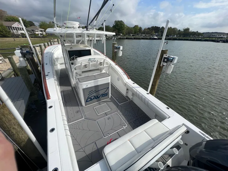 Slide: The Image of 2018 Buddy Davis 34 boat docked at a marina, featuring a spacious deck and modern amenities. - 11
