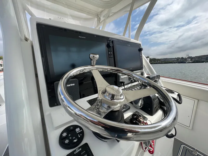 Slide: The Image of 2018 Buddy Davis 34 boat helm with dual navigation screens and stainless steel steering wheel. - 13