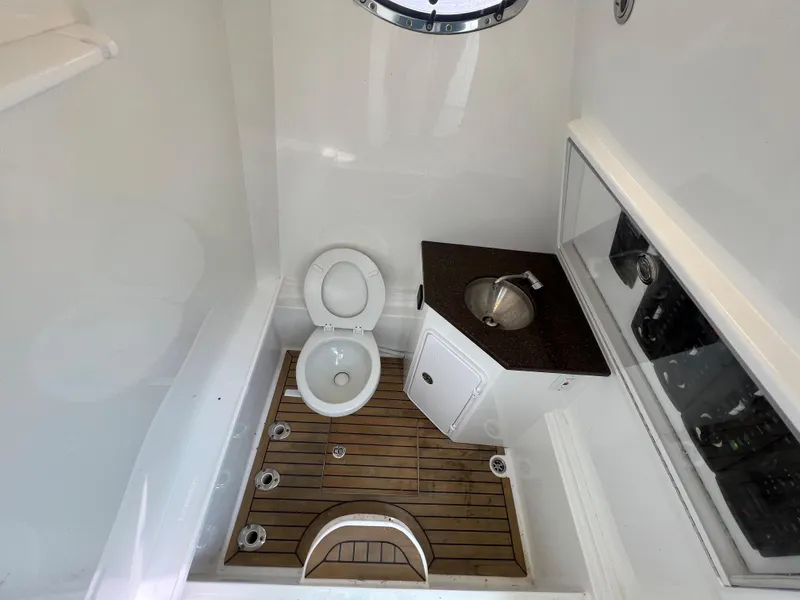 Slide: The Image of 2018 Buddy Davis 34 boat bathroom with toilet, sink, and wooden floor. - 15
