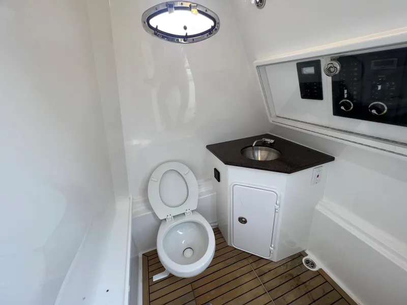 Slide: The Image of 2018 Buddy Davis 34 boat bathroom with toilet, sink, and wooden floor. - 16