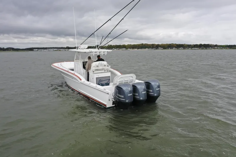 Slide: The Image of 2018 Buddy Davis 34 boat with triple Yamaha engines on a lake. - 2