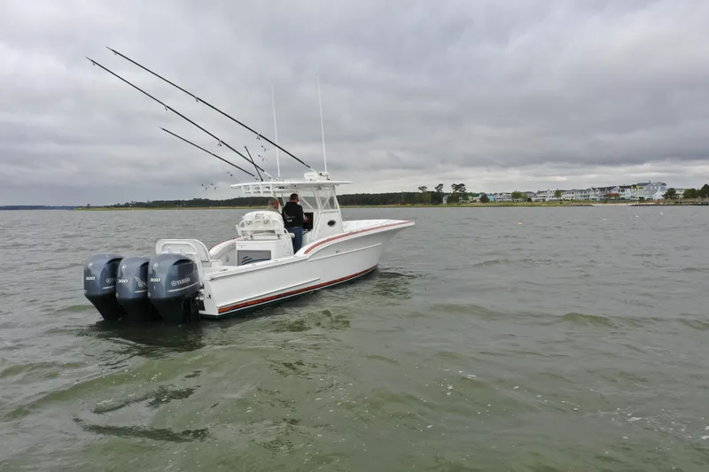 Slide: The Image of 2018 Buddy Davis 34 boat with triple outboard engines on open water. - 3