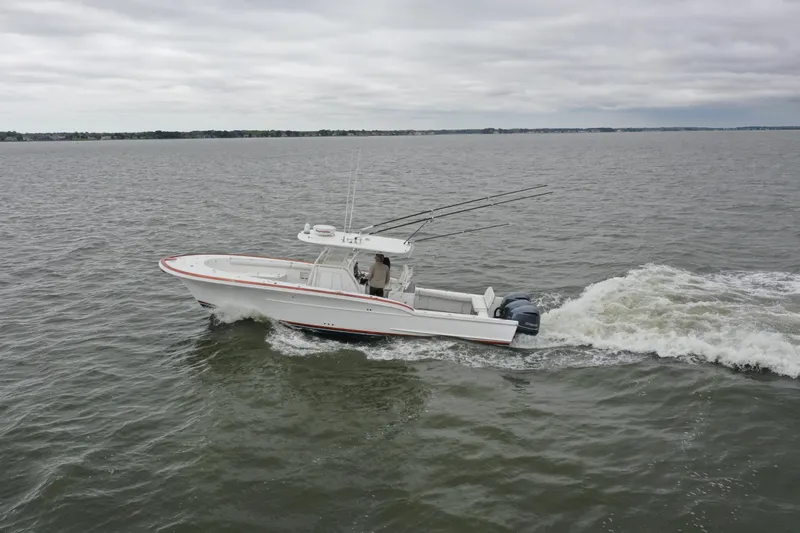 Slide: The Image of 2018 Buddy Davis 34 boat cruising on open water under cloudy skies. - 7