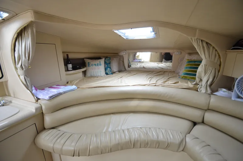 Slide: The Image of Interior cabin of a 1998 Sea Ray 310 boat with cozy seating and bedding. - 10