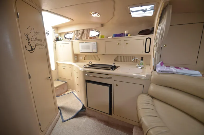 Slide: The Image of 1998 Sea Ray 310 boat interior with kitchenette and seating area. - 11