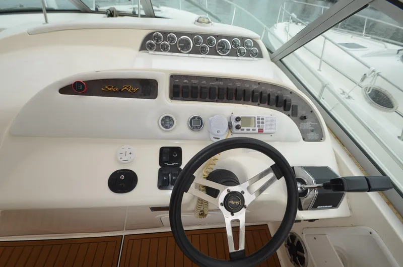 Slide: The Image of 1998 Sea Ray 310 boat helm with steering wheel and control panel. - 16