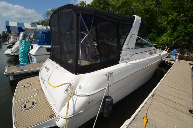 Slide: The Image of 1998 Sea Ray 310 boat docked at marina with black canopy. - 2