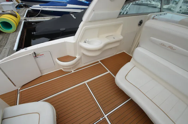 Slide: The Image of 1998 Sea Ray 310 boat interior with teak flooring and white cushioned seating. - 5