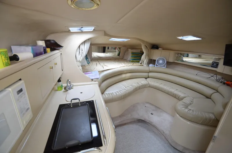 Slide: The Image of Interior of 1998 Sea Ray 310 boat with kitchenette and seating area. - 9