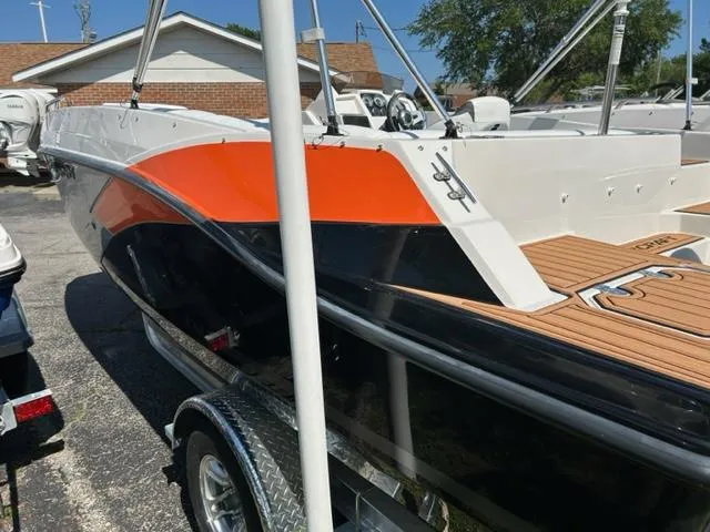 Slide: The Image of 2024 Starcraft SVX 191 boat with orange and black exterior, parked on a trailer. - 7