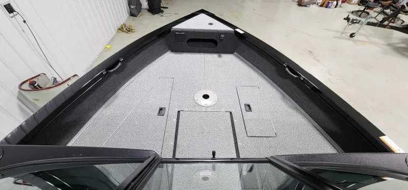 Slide: The Image of 2023 Lowe FM18PW boat interior, spacious deck with storage compartments. - 8