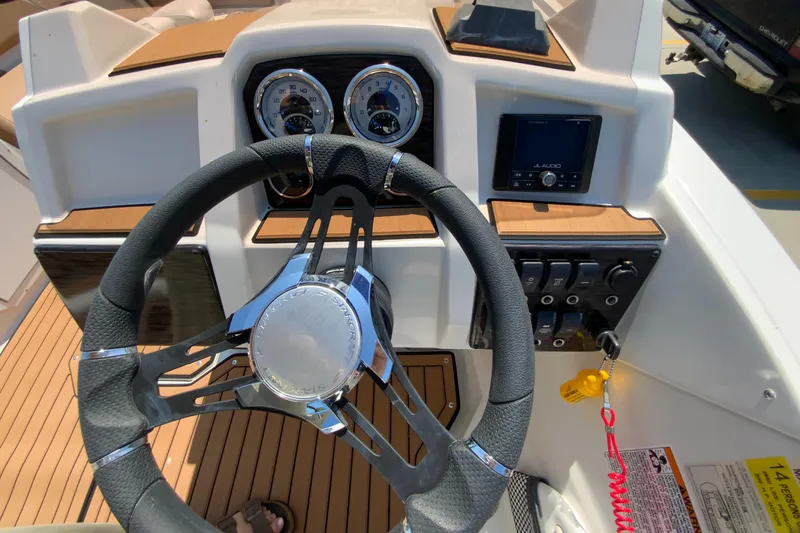 Slide: The Image of 2024 Starcraft SVX 211 boat dashboard with steering wheel, gauges, and control panel. - 12