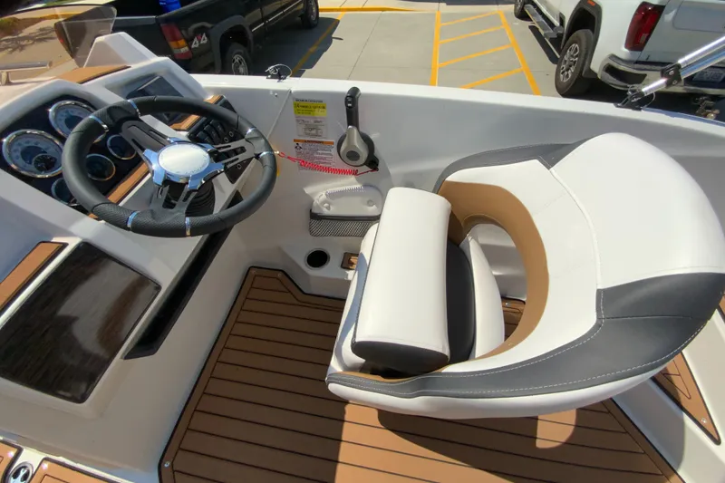 Slide: The Image of 2024 Starcraft SVX 211 boat cockpit with steering wheel and captain's chair. - 21
