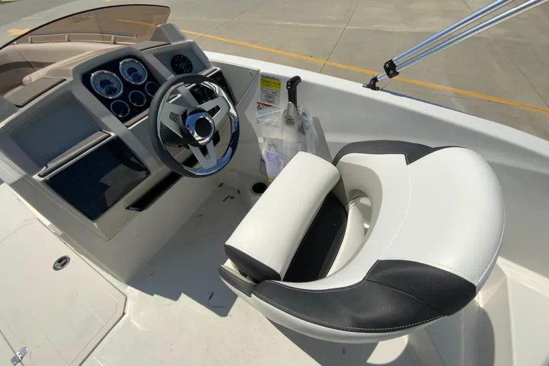 Slide: The Image of 2024 Starcraft SVX 191 boat cockpit with steering wheel and captain's chair. - 12