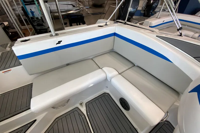 Slide: The Image of 2024 Starcraft SVX 231 boat interior seating with blue accents and gray flooring. - 6