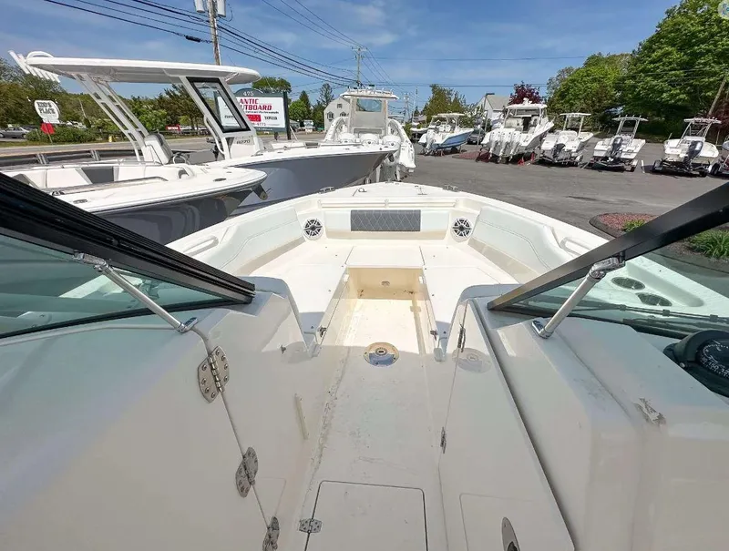 Slide: The Image of 2023 Cobia 240 Dual Console boat on display at a dealership. - 5