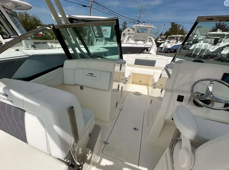 Slide: The Image of 2023 Cobia 240 Dual Console boat interior with seating and steering wheel. - 8