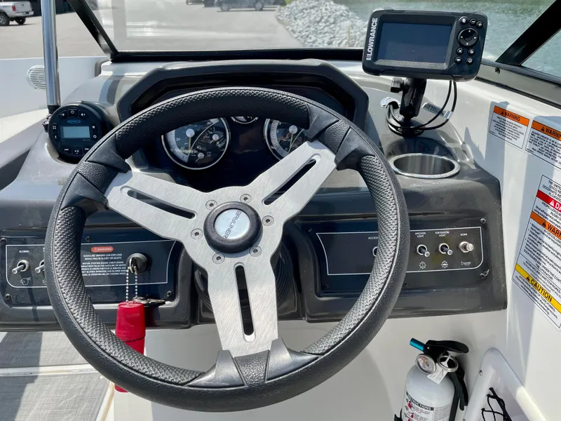 Slide: The Image of Steering wheel and dashboard of 2021 Bayliner VR5 boat with navigation equipment. - 14