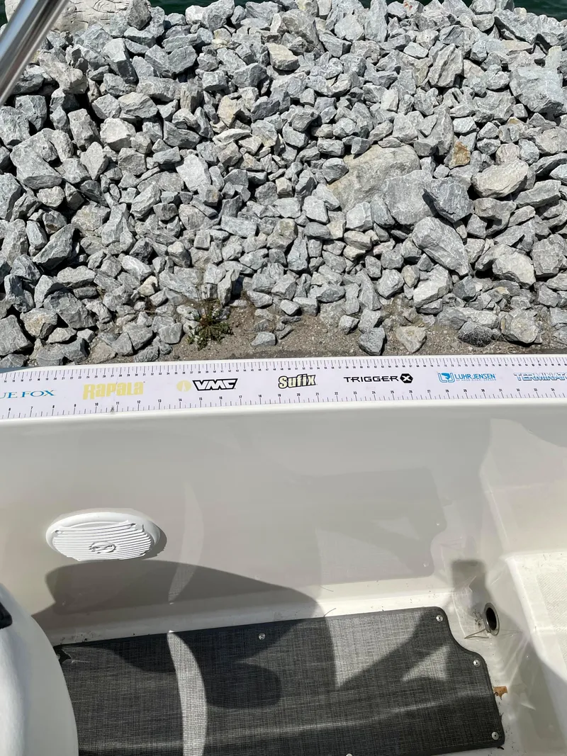 Slide: The Image of 2021 Bayliner VR5 boat interior with ruler and rocky shoreline background. - 22