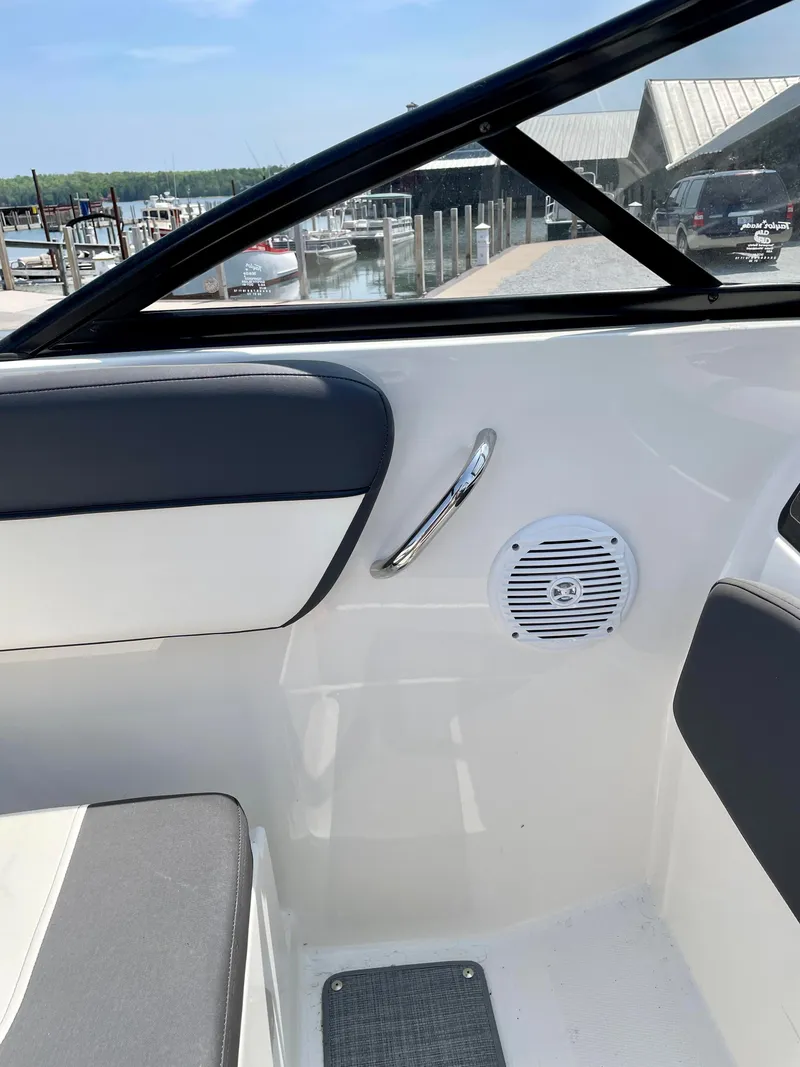 Slide: The Image of 2021 Bayliner VR5 interior with speaker, window, and seating at marina. - 25