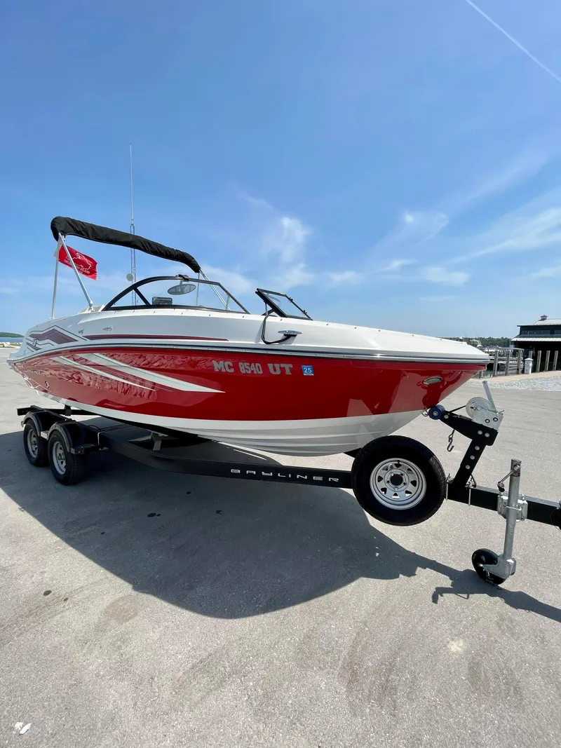 Slide: The Image of 2021 Bayliner VR5 boat on trailer, red and white design, parked under clear blue sky. - 3
