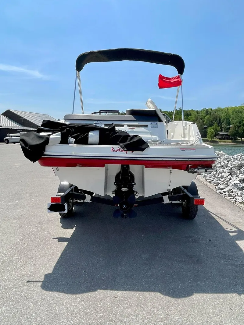 Slide: The Image of 2021 Bayliner VR5 boat on trailer, dockside with red flag, under clear blue sky. - 4