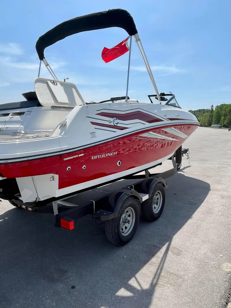 Slide: The Image of 2021 Bayliner VR5 boat on trailer, red and white design, parked outdoors. - 7