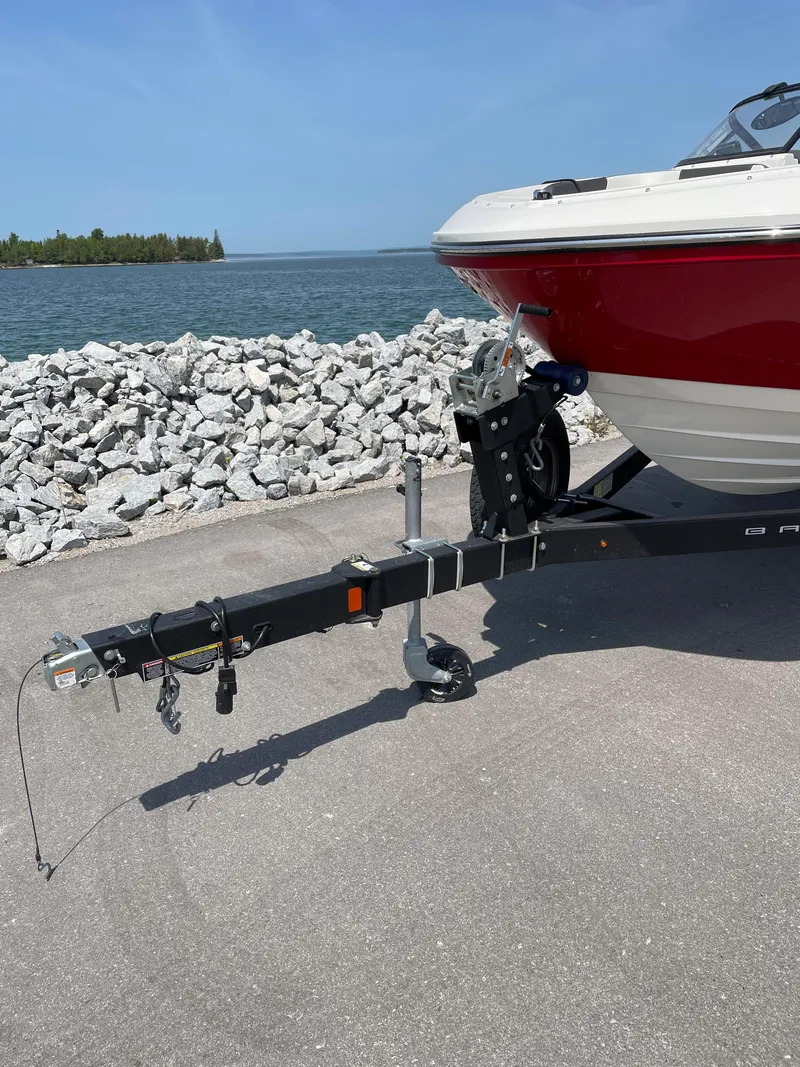 Slide: The Image of 2021 Bayliner VR5 boat on trailer by waterfront, clear sky, rocky shoreline. - 9